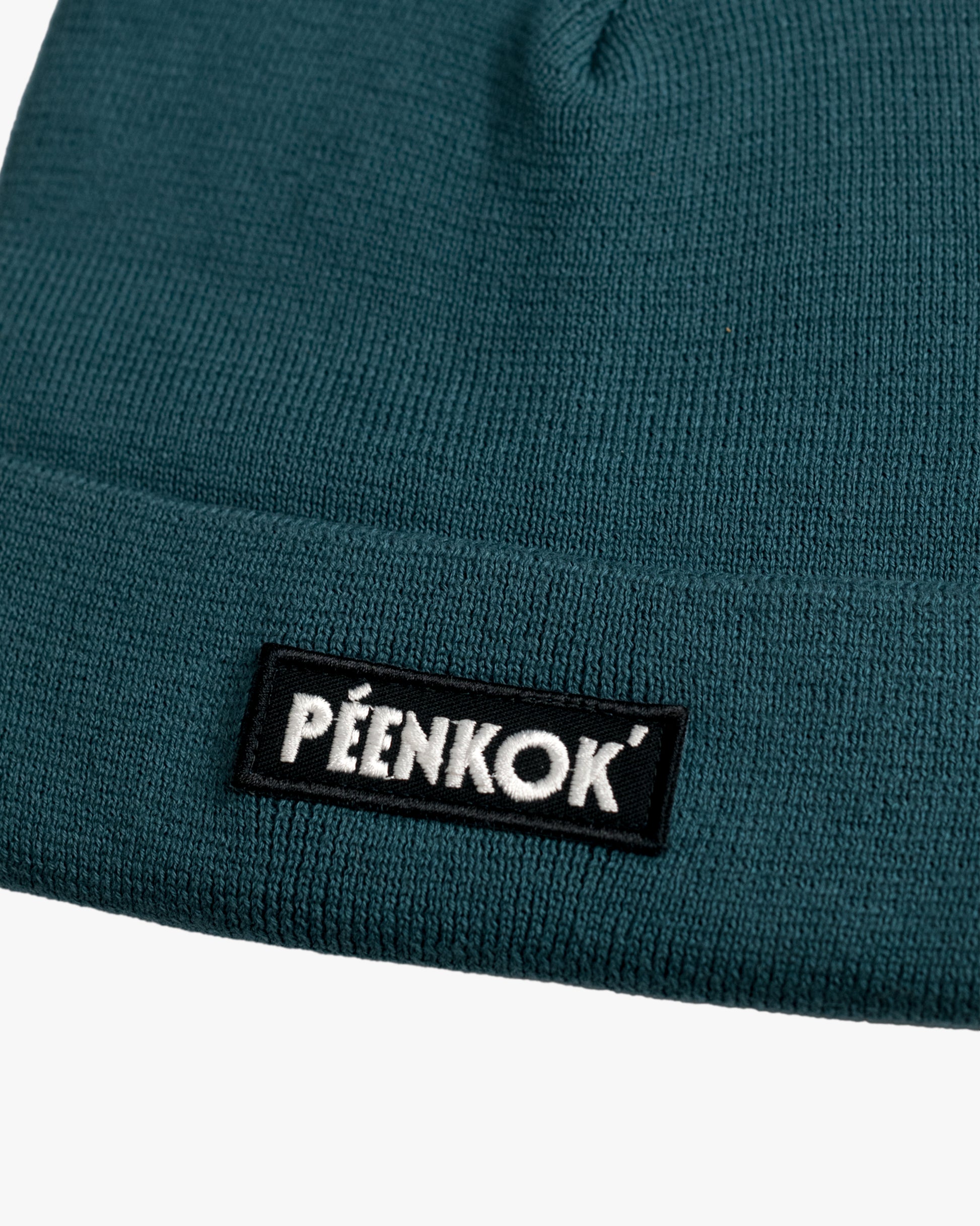 PÉENKOK’ | ORGANIC COTTON BEANIE TEAL WITH A WOVEN PATCH IN RECYCLED POLYESTER EMBROIDERY ON THE FRONT
